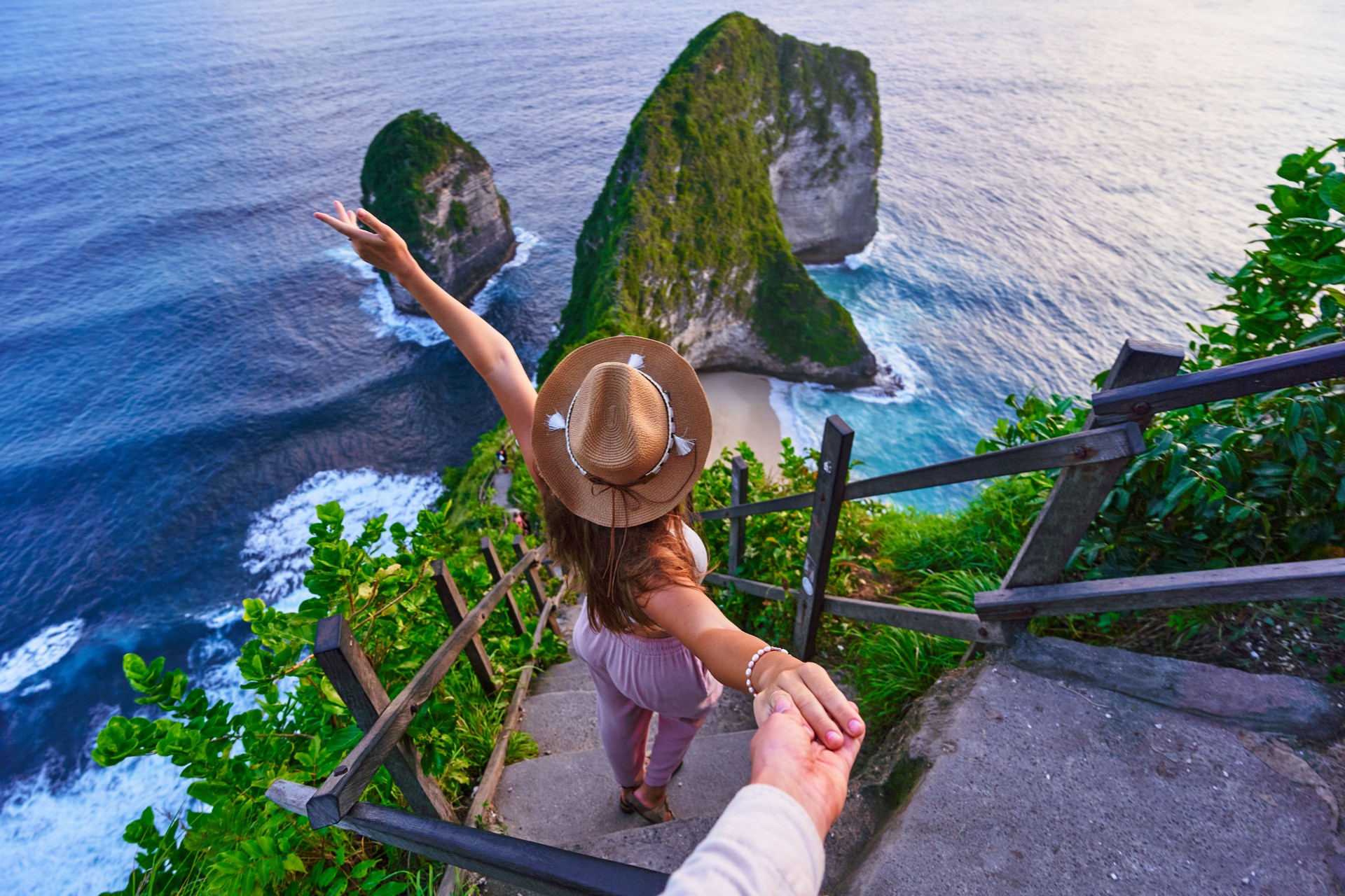 Follow me to scenic Kelingking beach. Traveling couple on vacation journey holiday to Nusa Penida Island in Indonesia, explore and travel to touristic beautiful destinations, honeymoon together