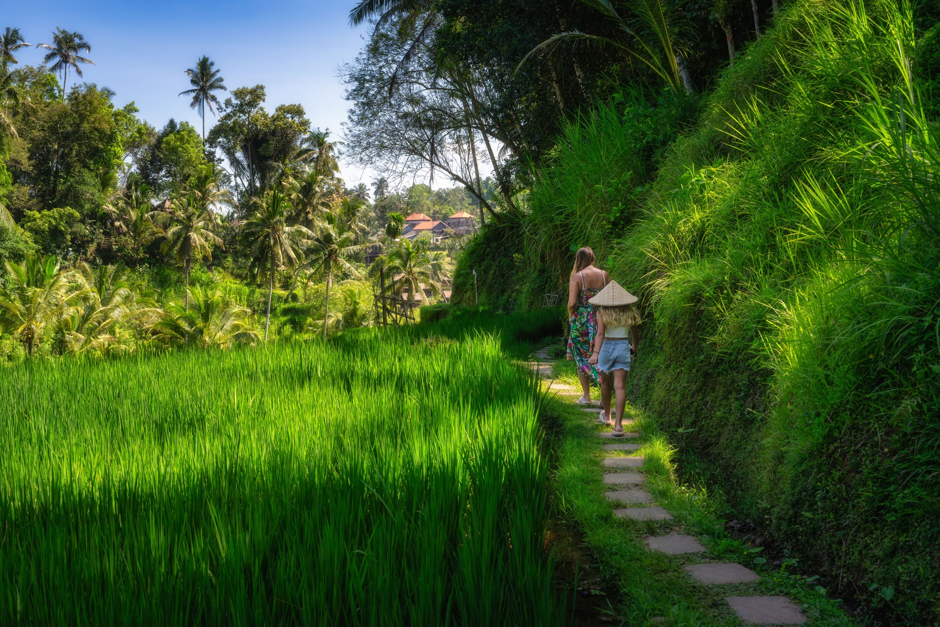 Explore Balis lush rice terraces with a child, enjoying breathtaking views in this beautiful green paradise